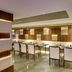 Hotel Grand Marian, Ludhiāna dining room with long table, upholstered chairs and wood-paneled walls