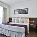 San Diego Suites Pampulha Hotel - Oficial room with king bed and large window in Belo Horizonte