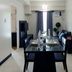 Home Edge Accommodations @ Tivoli Garden Residences in Manila: dining area with table, chairs, sofa, and TV