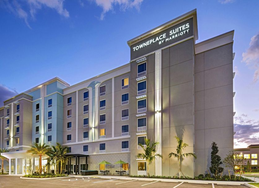 TownePlace Suites by Marriott Naples exterior at dusk with palm trees and a modern multi-story facade
