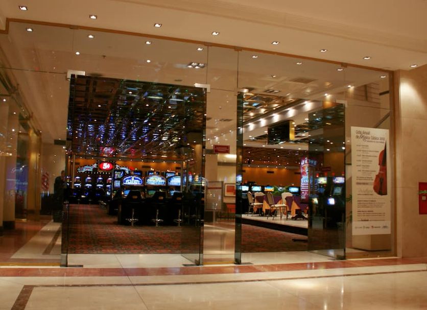 Amérian Hotel Casino Gala in Resistencia, glass entrance to casino with gaming machines inside