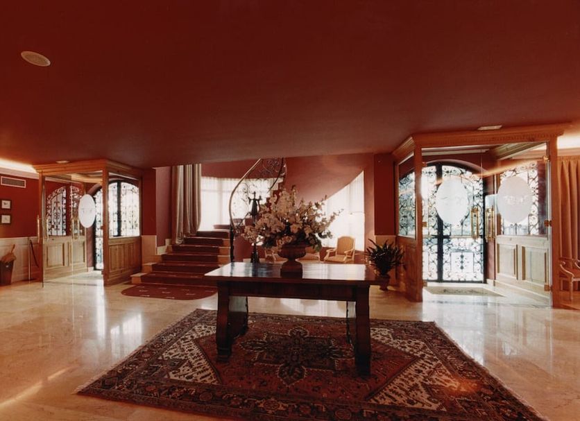 Hotel Fraga do Eume in Capela lobby with central table, rug, staircase and decorative floral arrangement