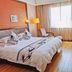 Zhejiang Xiangyuan Hotel (Wulin Square) room with bed, desk, armchair and large window in Hangzhou