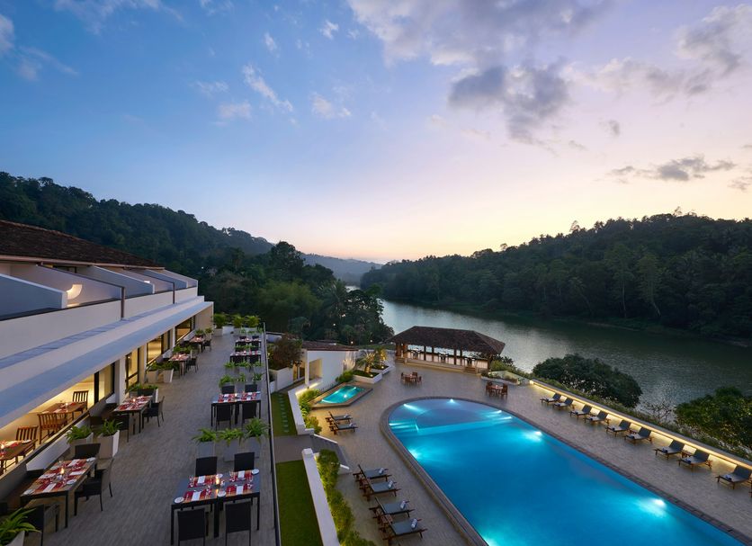 Cinnamon Citadel Kandy in Kandy with a riverside pool and terrace overlooking lush hills at sunset