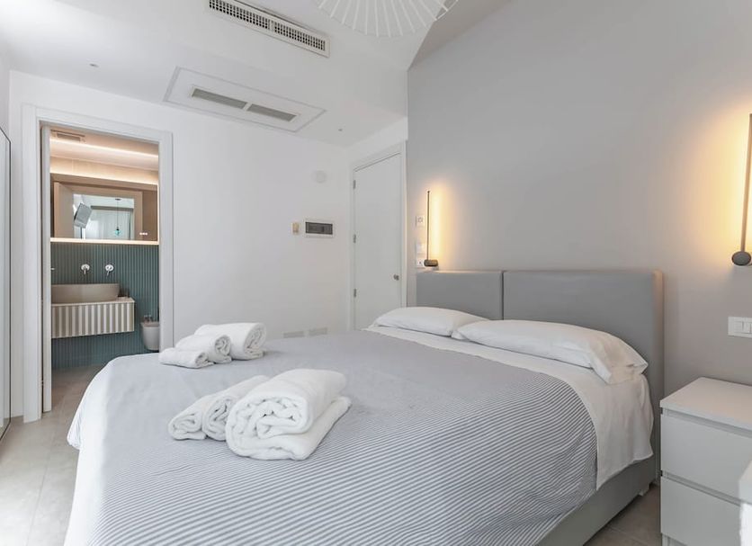 Malù Bed&Breakfast in Polignano a Mare, bright minimalist bedroom with double bed and ensuite doorway