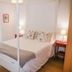 Casas e Quintas de Praia bedroom in Aveiro with four-poster bed, bedside lamps and sheer curtains