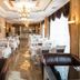 Boutique Hotel Buta Minsk elegant restaurant with set tables, chandeliers, and polished marble floor