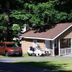 Rock Castle Resort in Lake George with a small cabin-style cottage, porch, and parked vehicles