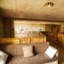 La Ferme De Noémie in Albertville offers a cozy wood-paneled lounge with sofa and warm lighting.
