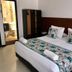 Hotel Casa Lamay in Bogotá: guest room with double bed, floral runner, and ensuite bathroom visible