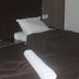 Hotel Meena Paradise in Visakhapatnam twin beds with dark bedding and rolled towels