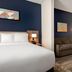 La Quinta Inn & Suites by Wyndham Montgomery room with king bed, sofa, lamp and modern blue accent wall