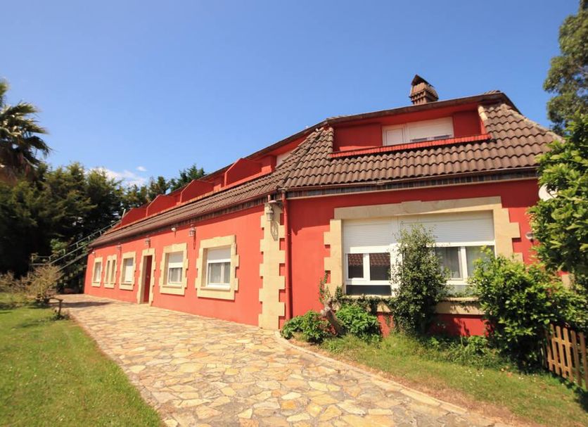 Arena Surf Hotel in Somo, red-roofed hotel exterior with stone path and garden