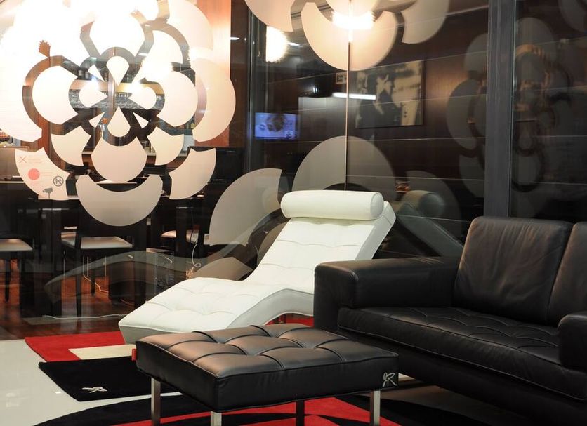 Hotel Portas De Santa Rita in Ermesinde lounge with black sofa, chaise lounge and patterned glass wall