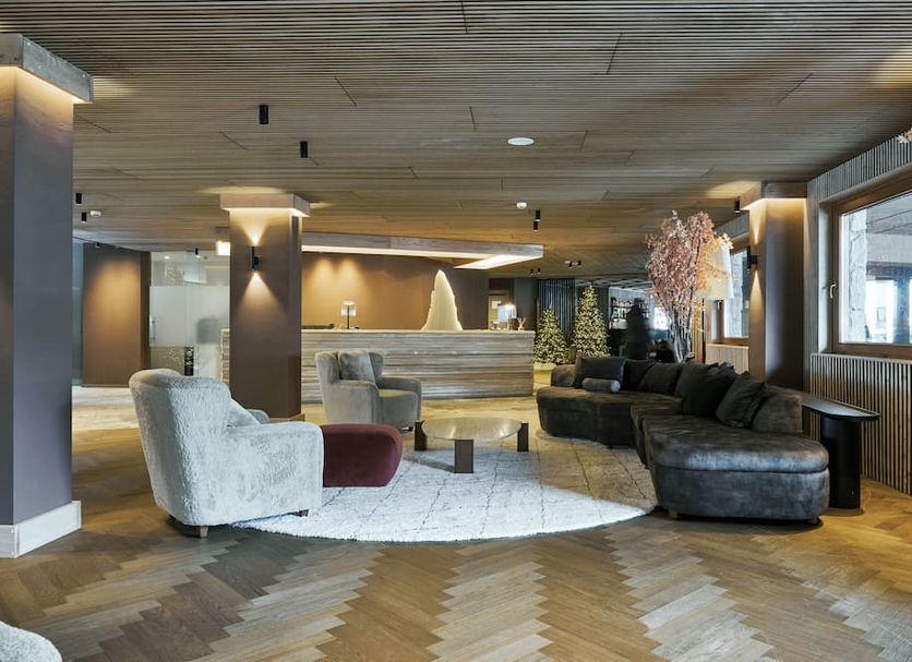 Hotel Europa in Breuil-Cervinia lobby lounge with curved sofa, armchairs and modern lighting
