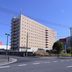Hotel Az Kitakyusyu Yahata Ten in Kitakyushu, beige high-rise hotel beside a road under clear blue sky