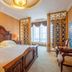 White Dolphin Hotel in Qinzhou bedroom with carved wood bed, gold lattice screens, and large window