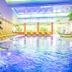 Hotel Schmelmer Hof in Bad Aibling indoor pool with waterfall, lounge chairs and colorful ceiling lights
