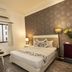 Vilion Central Hotel room in Ho Chi Minh City with queen bed, patterned accent wall, and window seating area