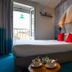 Hôtel Le Bord'O Vieux Port room in La Rochelle with bed, balcony doors and large wall mural.