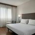 AC Hotels by Marriott Bologna guest room with king bed, desk, chair and large window with sheer curtains