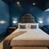 The Winston Solvang guest room with blue walls, king bed, and decorative headboard in Solvang.