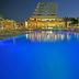 Vrissiana Boutique Beach Hotel in Protaras with a glowing blue pool and beachfront building at night