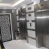 White Fort Hotel Dubai elevator lobby with stainless steel lifts and patterned door