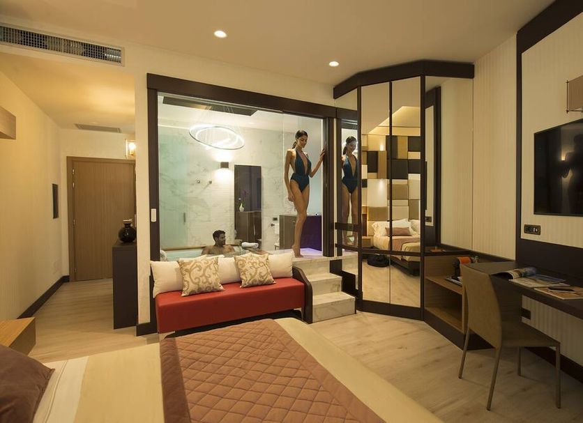 Thotel Lamezia in Feroleto Antico guest room with sofa, desk, wall TV and glass-enclosed bathroom