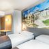 B&B Hotel Bonn-West room with two beds, desk, and Bonn mural wall art