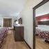 Red Roof Inn & Suites Denton guest room with two beds, desk, and mirrored dresser in Denton