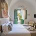 Palazzo Ducale Venturi in Minervino di Lecce: elegant guest room with open green doors to patio