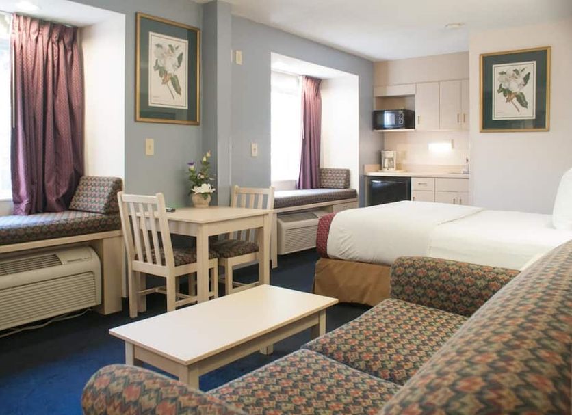 Hometown Inn & Suites Jacksonville Butler Blvd./Southpoint room with sofa, table, bed, and kitchenette