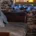 Abbaye De Maizieres in Beaune, lounge with stone wall, mirrored frame and cushioned sofa