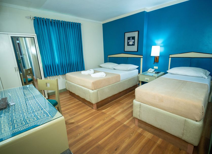 New Dawn Pensionne House, Cagayan de Oro: bright hotel room with two single beds and blue accent wall
