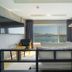 Jk Hotel Busan room with bed, TV, and large window overlooking the sea and mountains