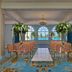 British Colonial Nassau event room with coral chairs, white aisle, chandeliers and ocean view.