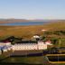 Hunavellir Guesthouse in Blonduos with guesthouse buildings and a lake-and-mountain landscape