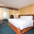 Fairfield Inn & Suites by Marriott Orlando Kissimmee/Celebration guest room with king bed and sitting area