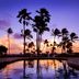Hilton Garden Inn Kauai Wailua Bay in Kapaa with tropical pool and palm tree sunset reflection