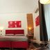 Sangiuliano114 B&B Catania room with red accents, double bed, wall art and brick feature wall