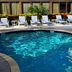 Holiday Inn Express Boca Raton-West poolside patio with lounge chairs and palm plants in Boca Raton