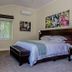 Clos Malverne Wine Estate room in Stellenbosch with king bed, window view, desk, and floral wall art