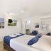 Beach House Motel in Townsville guest room with two beds, desk, wall art, and en suite bathroom
