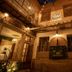 Che Juan Hostel Ba in Buenos Aires, warmly lit courtyard with arched entry, windows and hanging plants