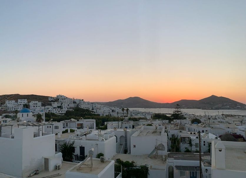Minoa Hotel in Naousa with whitewashed buildings and sunset views over the sea and hills