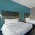 Tru by Hilton Austin Airport guest room with two beds and teal accent wall in Austin
