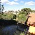 Pousada Atalaia in Campos do Jordão with hillside forest and nearby rooftops under a blue sky