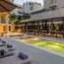 Divani Escape in Vouliagméni with outdoor pool, loungers and shaded terrace dining area