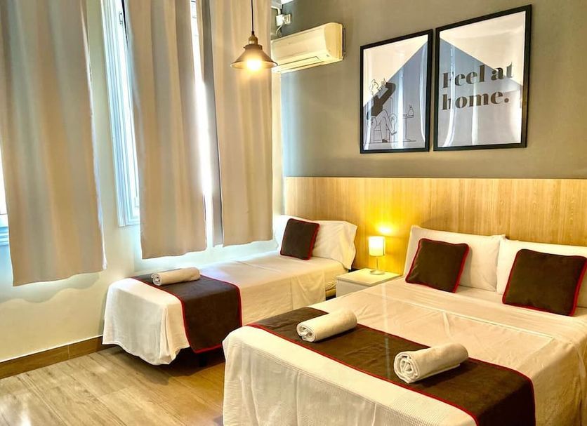 Ch Las Murallas Madrid twin room with three single beds, wall art, and window curtains
